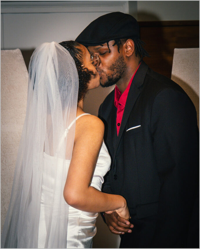 Bruidspaar tijdens de kus in stadhuis in Apeldoorn vastgelegd door Cue Fotografie. Peter Polman bruiloftsfotograaf.
